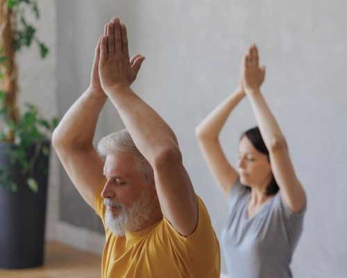 hombre-mujer-hacen-yoga-entrenador-principal-estudio-deportivo-mujeres-adultas-jovenes-meditan-ojos-cerrados_423170-3009